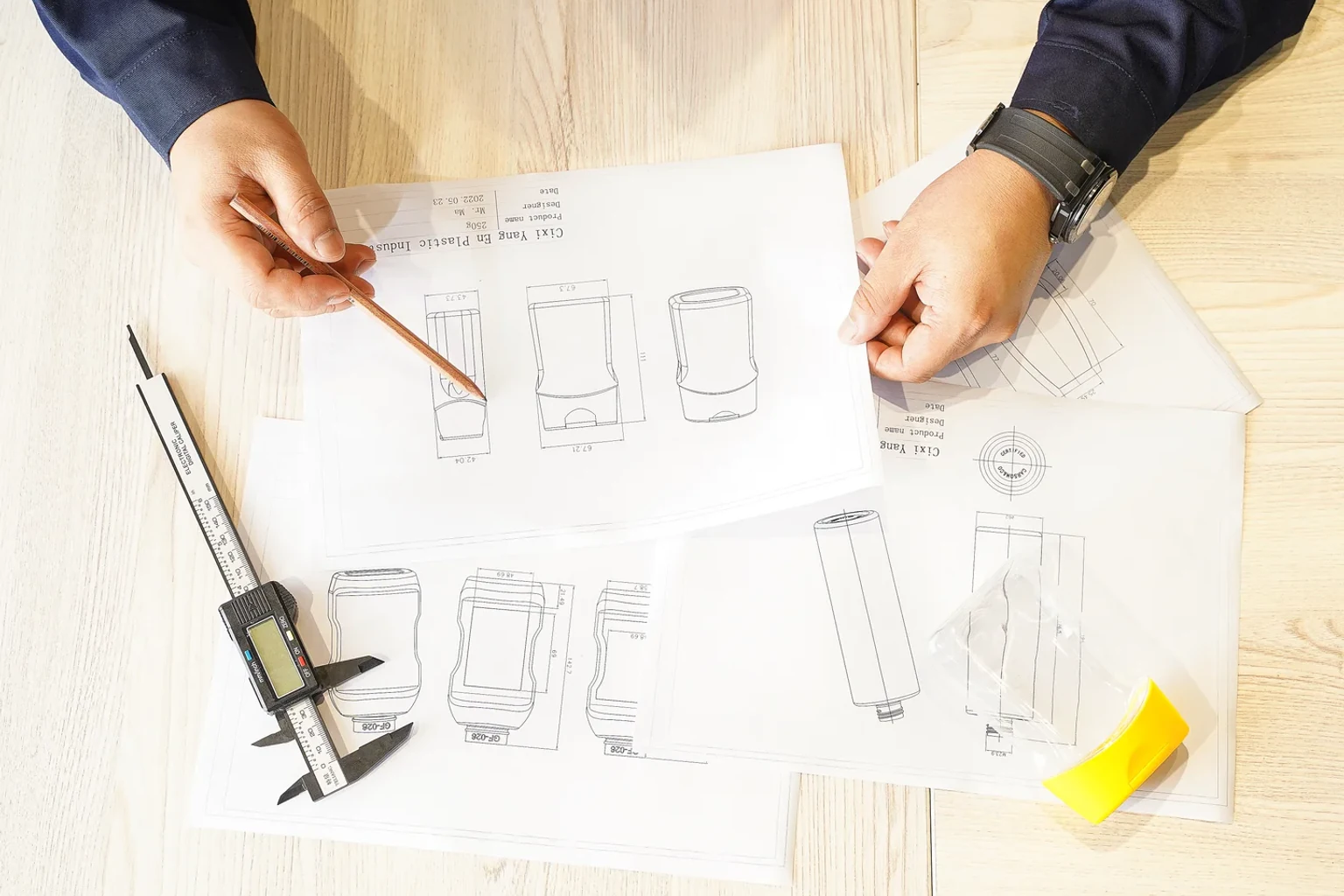 Packaging engineer reviewing bottle drawings, dimensions and a closure sample